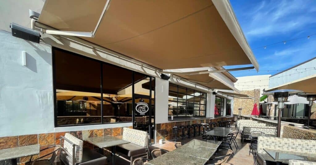 Commercial Awnings Installed Over a Restaurant Patio to Provide Adjustable Shade and Comfortable Outdoor Dining
